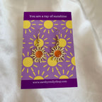 Gold and orange dangle earrings in gift bag on sunshine card