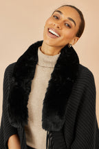 Shrug Yumi noir à col en fausse fourrure avec ourlet à pompons